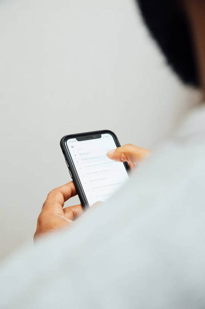 Human hand pointing at mobile phone with finger